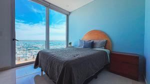 ein Schlafzimmer mit einem Bett mit einem großen Fenster in der Unterkunft Condominios de lujo en el corazón de la Zona Dorada en Camino Al Mar. in Mazatlán + 119 Fotos