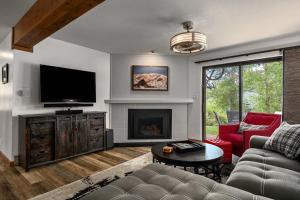 a living room with a couch and a tv and a fireplace at Hot tubs and pool -Looping shuttle- Cozy fireplace in Steamboat Springs