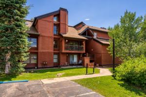 a large brick house with a balcony and a yard at Hot tubs and pool -Looping shuttle- Cozy fireplace in Steamboat Springs