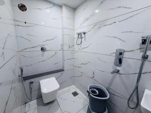 Un baño blanco con inodoro y lavabo. en Hotel JK Palace, en Ujjain 57 fotos más