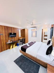 Un dormitorio con una cama grande y un escritorio. en Hotel JK Palace, en Ujjain