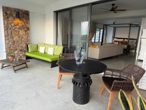 a living room with a table and a couch at Egret at Galley Bay View in Five Islands Village