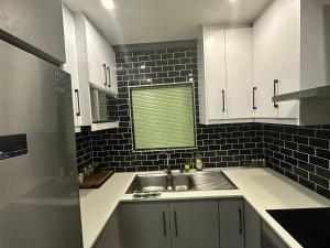 a kitchen with white cabinets and a sink and a window at 29 on Windsor-2 Bedroom House in Silver Sands
