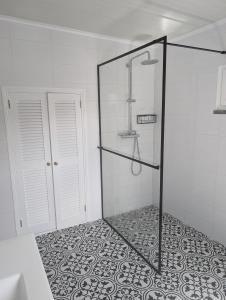 ein Bad mit Dusche und Fliesenboden in der Unterkunft Casa de São João in São João + 18 Fotos