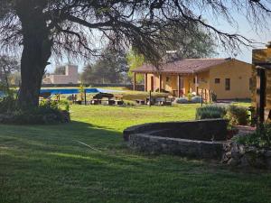 ein Haus in einem Garten mit einem Baum in der Unterkunft Vistas del Yásta cabaña para un solo grupo in Cafayate