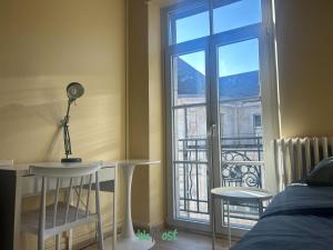 1 dormitorio con escritorio y ventana con vistas en COMM - Proudhon 9 - SC - Petit studio moderne à Besançon, en Besançon