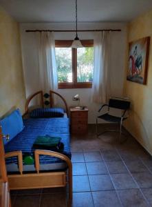 a bedroom with a bed and a chair and a window at Casa de Galindo in Águilas