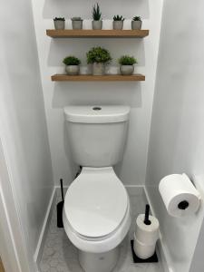 ein Badezimmer mit Toilette und einem Regal mit Pflanzen in der Unterkunft East Hollywood Modern Spacious Bungalow in Los Angeles