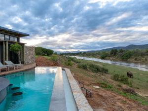 Izakithi River Villa في ماليلين: حمام سباحة مع إطلالة على النهر