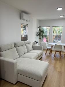 ein weißes Wohnzimmer mit einer Couch und einem Tisch in der Unterkunft East Hollywood Modern Spacious Bungalow in Los Angeles