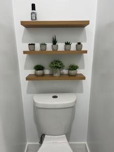 ein Badezimmer mit WC und Pflanzen auf Regalen in der Unterkunft East Hollywood Modern Spacious Bungalow in Los Angeles + 84 Fotos