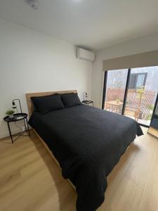 ein Schlafzimmer mit einem schwarzen Bett und einem großen Fenster in der Unterkunft East Hollywood Modern Spacious Bungalow in Los Angeles