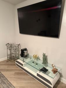 un tavolo in vetro con TV a parete di Hollywood Apartment FREE Parking & Pool Close to Studios Universal a Los Angeles