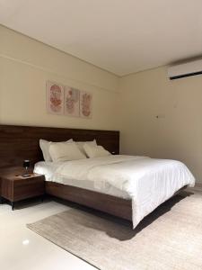 ein Schlafzimmer mit einem großen Bett mit hölzernem Kopfteil in der Unterkunft Valley View in Nizwa + 8 Fotos