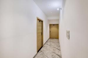 MohaliTownhouse Mohali Bus Terminal Formerly Hotel Hm Crystal的走廊设有两扇木门和一堵墙