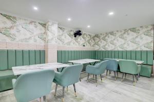 MohaliTownhouse Mohali Bus Terminal Formerly Hotel Hm Crystal的餐厅拥有绿色的墙壁和桌椅