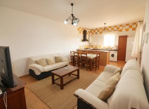 ein Wohnzimmer mit einer weißen Couch und einer Küche in der Unterkunft Casas en el palmar in El Palmar + 20 Fotos