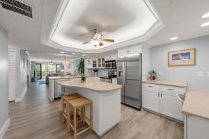 a kitchen with white cabinets and a ceiling fan at Pointe Santo B25 in Sanibel