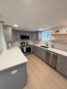 a large kitchen with white counters and stainless steel appliances at Lake House get away in Whitsett +15 photos