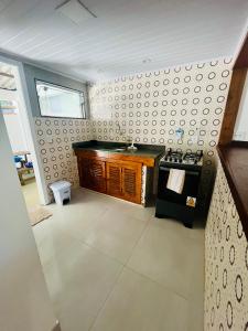 a bathroom with a sink and a stove in a room at Casa Canto de Geribá, 10 min da Praia in Búzios +4 photos