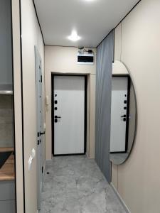 einen Flur mit zwei Türen und einem Spiegel in der Unterkunft Сейфулина 31 in Balqasch