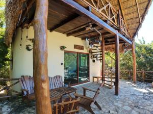 Un patio al aire libre con sillas y techo de paja. en Hotel Aldea Maya, en Valladolid