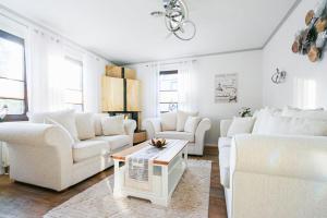 a living room with white couches and a table at Ferienhaus Poolaris in Pruchten