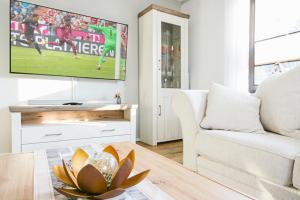 a living room with a white couch and a tv at Ferienhaus Poolaris in Pruchten +17 photos