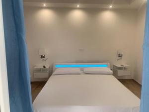 a bedroom with a large white bed with two lights at Panoramic View in Terracina