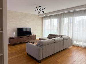 a living room with a couch and a flat screen tv at Seaview Apartment in Bečići