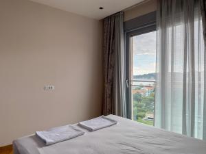 a bedroom with a bed and a large window at Seaview Apartment in Bečići