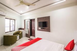 a bedroom with a bed and a flat screen tv at Hotel O Eagle Fantasy in Vānivilāsa Puram
