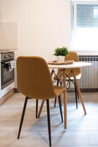 - une table à manger avec 2 chaises et une table blanche dans l'établissement Cozy Studio w Floor Heating & King Size Bed, à Sesvete