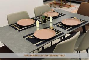 Una mesa con platos y cargadores sobre ella en Rizz Santorini Apartment, en Negombo