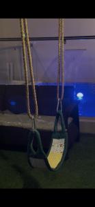 a swing in a room with a bed at Thuraya chalet in Nizwa