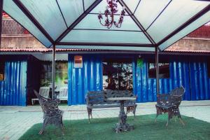 a patio with a table and chairs and a chandelier at Villa de Recriary in Campos do Jordão