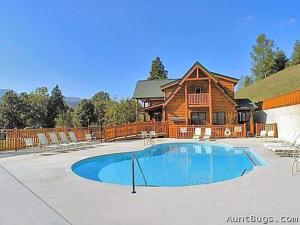 a large swimming pool in front of a log house at Starry Nights #222 in Pigeon Forge