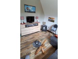 a living room with a tv and a couch at Ferienhaus Seeschwalbe in Dornumersiel in Dornumersiel