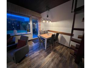 a dining room with a table and chairs and a window at Ferienhaus Seeschwalbe in Dornumersiel in Dornumersiel