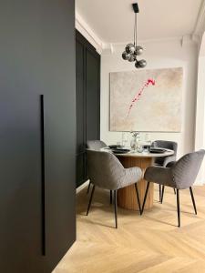 Un comedor con una mesa y sillas y un cuadro. en Stylish Modern-Victorian Apartment with Balcony, en Staré Mesto 6 fotos más