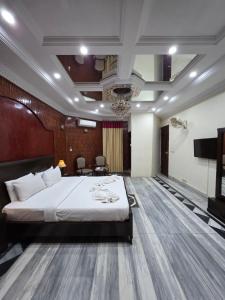 a hotel room with a bed and a flat screen tv at Executive Galaxy Guest House Islamabad in Islamabad