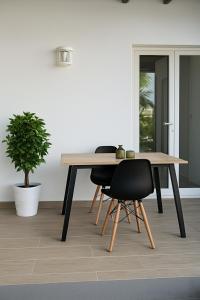 a wooden table with two chairs and a plant at Fleur de Lys 2 in Petit-Bourg