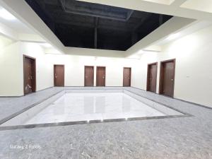 Habitación vacía con pared blanca y puertas de madera en Shrimant Executive Lodging, en Jejūri