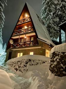 un edificio cubierto de nieve por la noche en KUĆA NENO, en Vlašić
