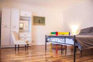 ein Schlafzimmer mit einem Bett, einem Stuhl und einer Kommode in der Unterkunft Apartment on high street in Saltdean