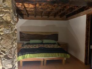 une chambre avec un lit dans un mur de pierre dans l'établissement Cabañas Quinta Áthas, à Huasca de Ocampo