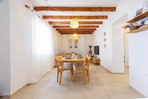 ein Esszimmer mit einem Holztisch und Stühlen in der Unterkunft Casa el corralón in Salobreña