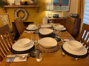 una mesa de comedor con platos y copas de vino en Crispins Corner, en Stedham