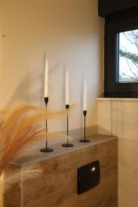 two candles on a table with feathers at D'MMASS Holiday home Istria in Martinski
