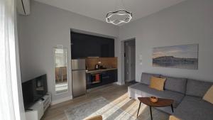 a living room with a couch and a tv at KYANA Luxury KVA II in Kavála